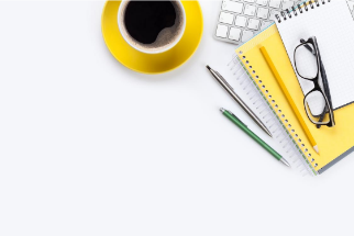Bürotisch mit Kaffee, Büchern, Stiften, Tastatur, Brille